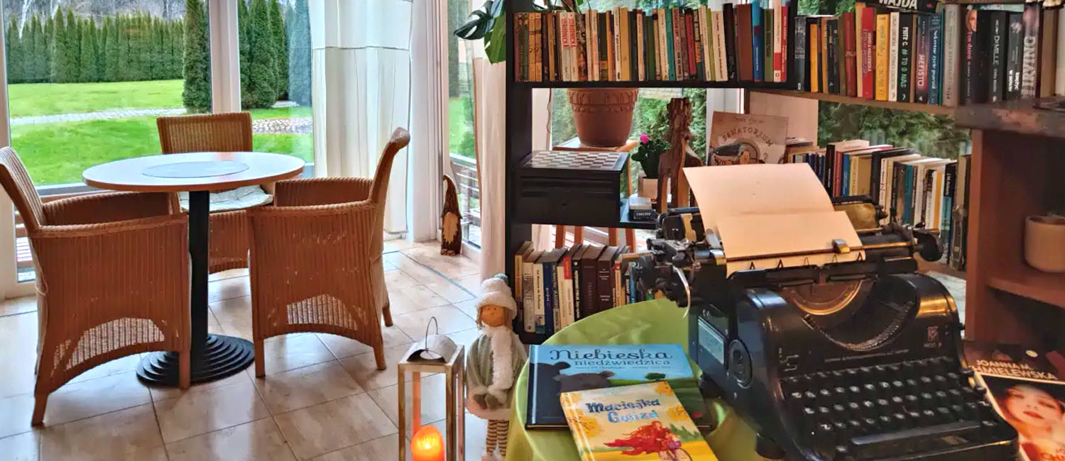 pokój wypełniony mnóstwem książek i maszyną do pisania