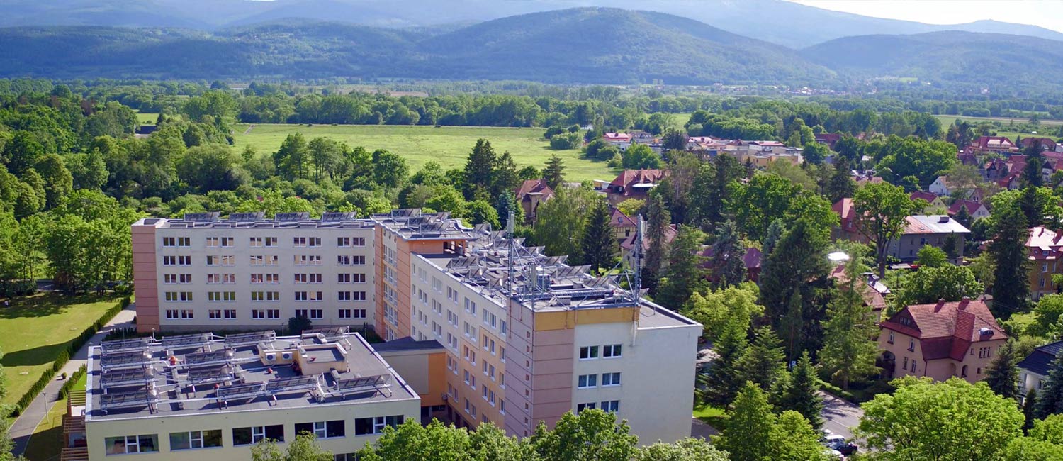 widok na budynek sanatorium z lotu ptaka z górami w tle